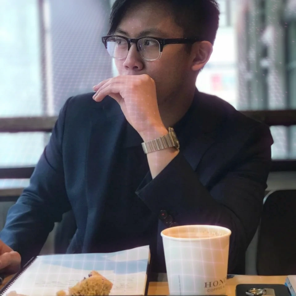 Thomas T Vo sitting by a window with a coffee